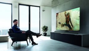 man in suit watches hd tv